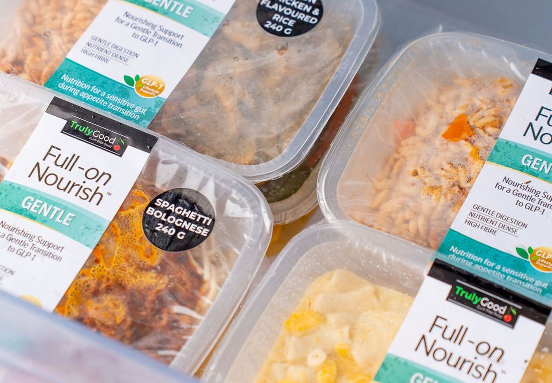 Fourteen Full-on meal trays stacked in one standard freezer drawer